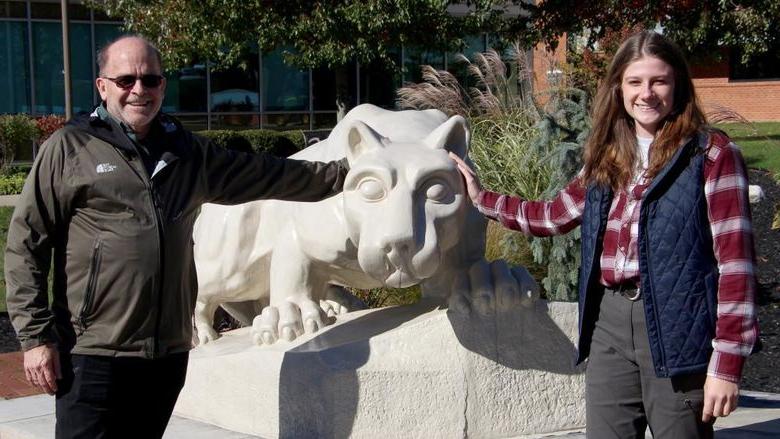 Two people stand on either side of the Lion Shrine