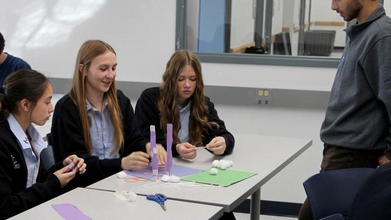 Students attending Discover Engineering Day at Penn State DuBois discuss their design ideas for a project with a member of the Engineering Ambassadors Program, who offered insights and suggestions on improvements.